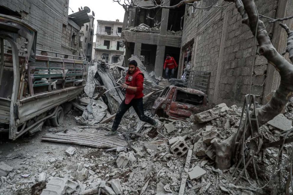 PHOTO: A red crescent volunteer runs after a bombing, in rebel-held Douma, Eastern Ghouta, Syria, Feb. 22, 2018. More than 25 people were killed in Douma after several airstrikes and shelling by forces allegedly loyal to the Syrian Government.