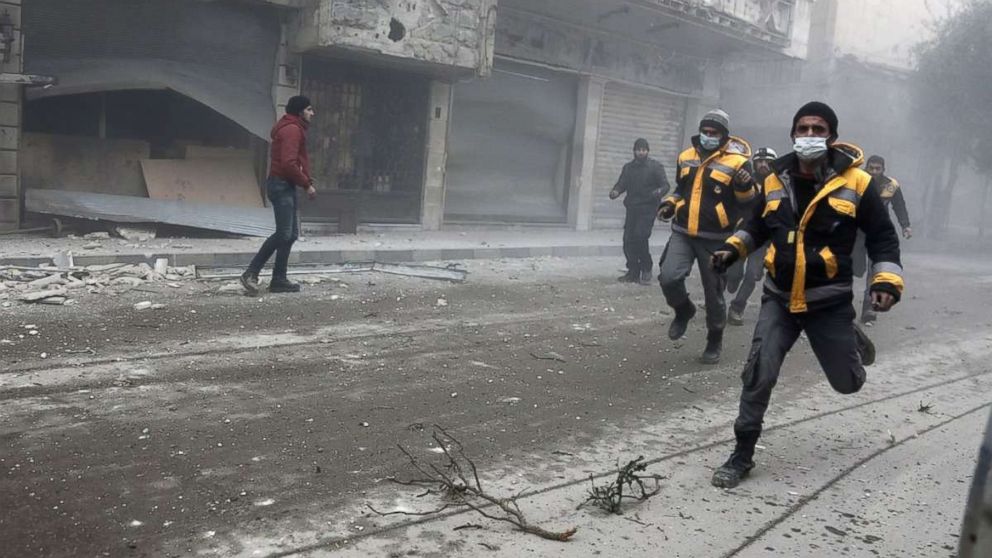 PHOTO: Syrian rescuers and civilians run at the site of Syrian government bombardments in Hamouria, in the besieged Eastern Ghouta region on the outskirts of the capital Damascus on Feb. 22, 2018. 