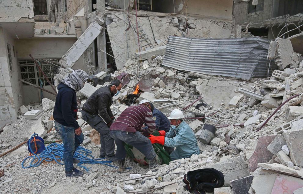 PHOTO: Syrian civil defense volunteers pull out the body of a victim as they search for survivors from beneath a collapsed building following reported bombardment in Haza, in the besieged Eastern Ghouta region on Feb. 26, 2018.