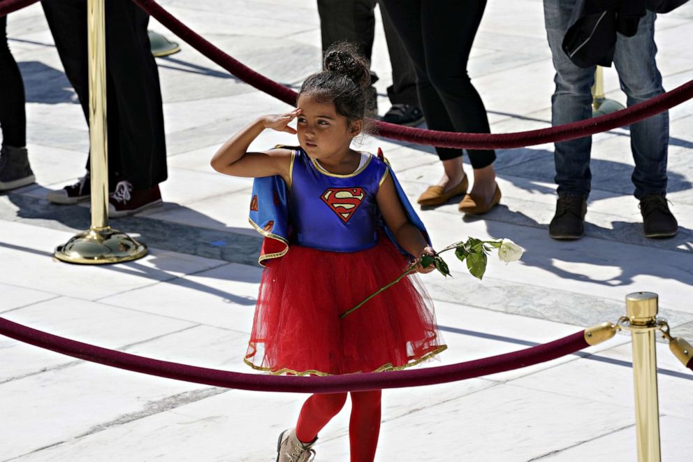 PHOTO: A child in a Supergirl costume pays respects as Justice Ruth Bader Ginsburg lies in repose under the Portico at the top of the front steps of the U.S. Supreme Court building in Washington, D.C., Sept. 23, 2020.