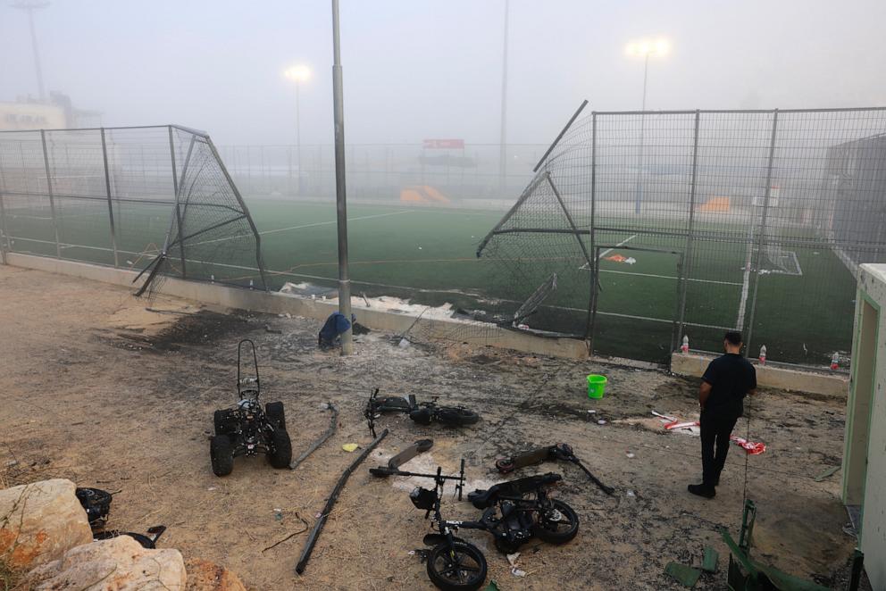 PHOTO: A man stands near a damaged gate around a football pitch after a reported strike from Lebanon fell in Majdal Shams village in the Israeli-annexed Golan area on July 28, 2024.