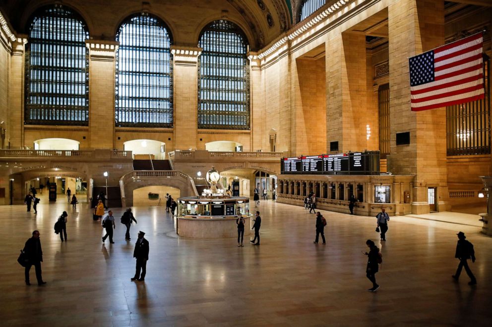 PHOTO: An MTA conductor stands in a beam of light at Grand Center Terminal that is sparsely populated during rush hour due to COVID-19 concerns in New York City, March 20, 2020.