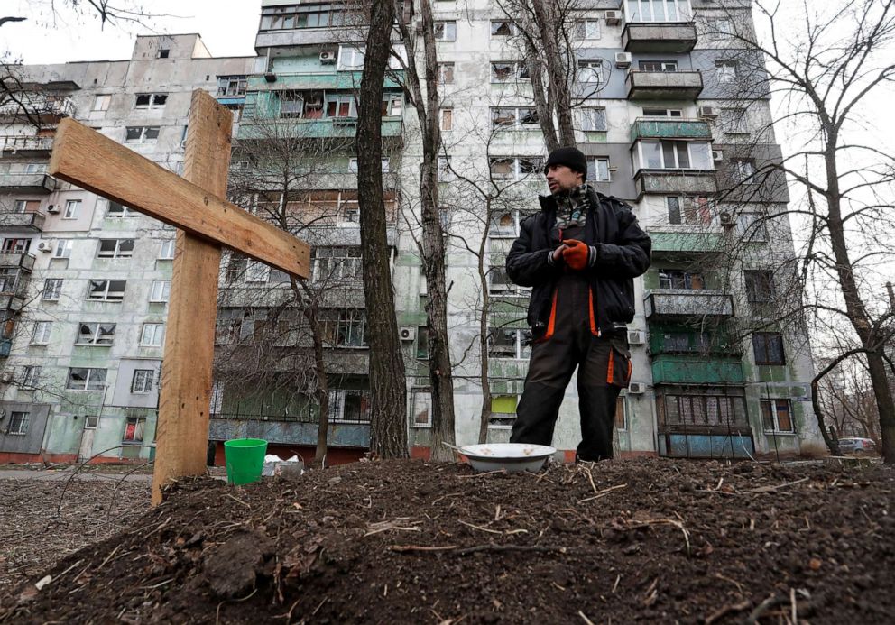 FILE PHOTO: Local resident Pavel, 42, stands next to the grave of his friend Igor, who was killed by shelling while they were riding together in a car amid Russia's invasion of Ukraine, in a residential area of Mariupol, Ukraine, March 30, 2022.