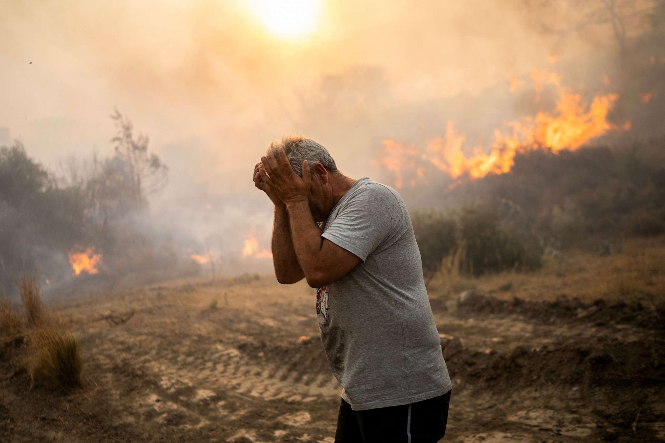 PHOTO: A man reacts as a fire burns into the village of Gennadi on the Greek Aegean island of Rhodes, on July 25, 2023.