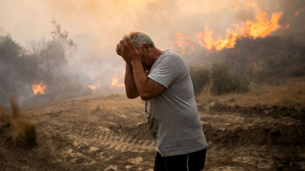 PHOTO: A man reacts as a fire burns into the village of Gennadi on the Greek Aegean island of Rhodes, on July 25, 2023.