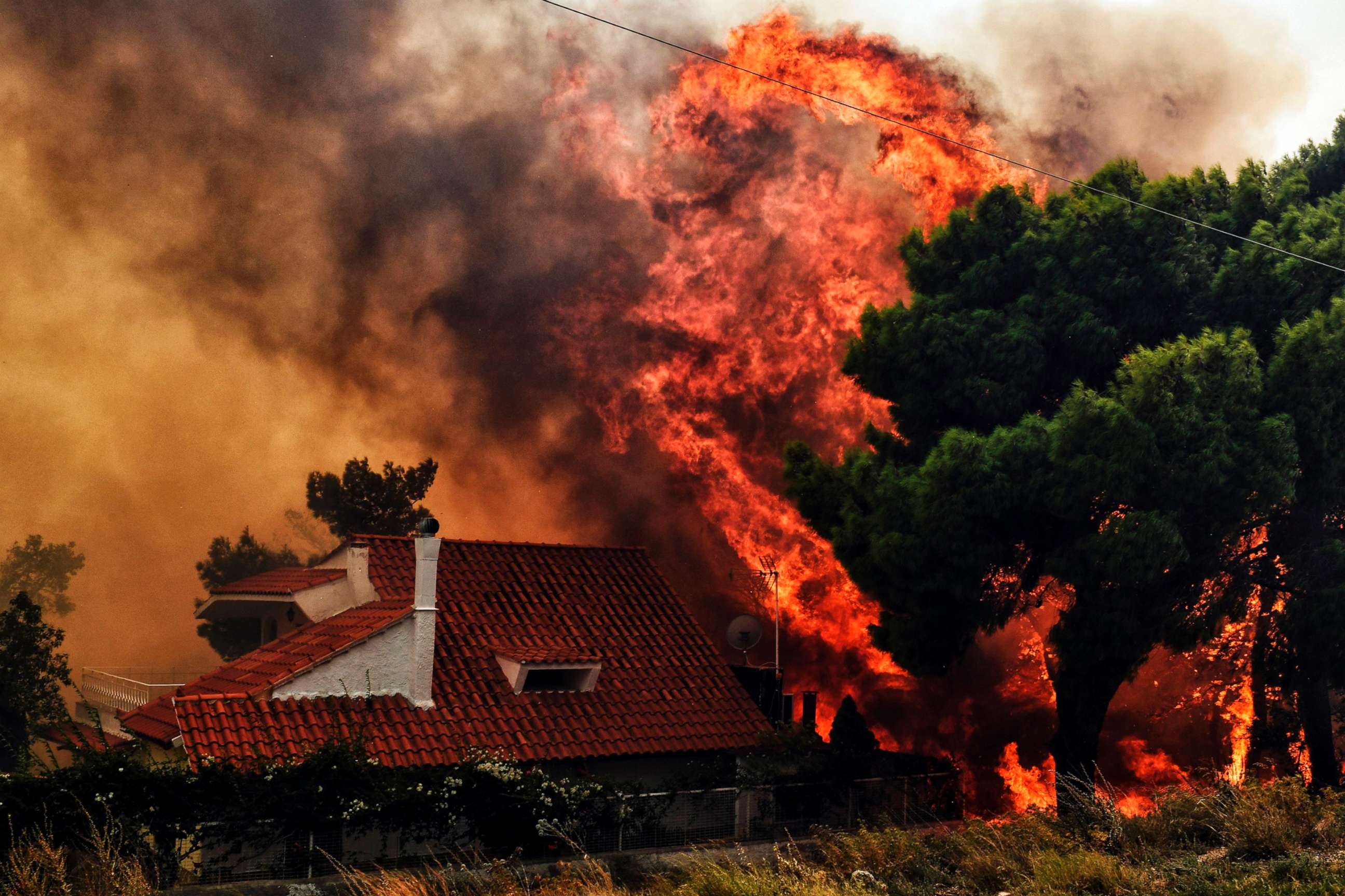 PHOTO: A house is threatened by a huge blaze during a wildfire in Kineta, near Athens, on July 23, 2018.