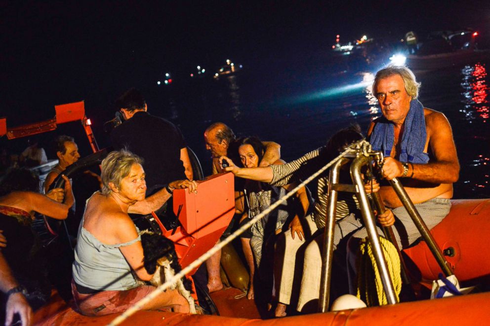 PHOTO: Rescuers and volunteers help local people evacuate the village of Mati during a wildfire near Athens, July 23, 2018.