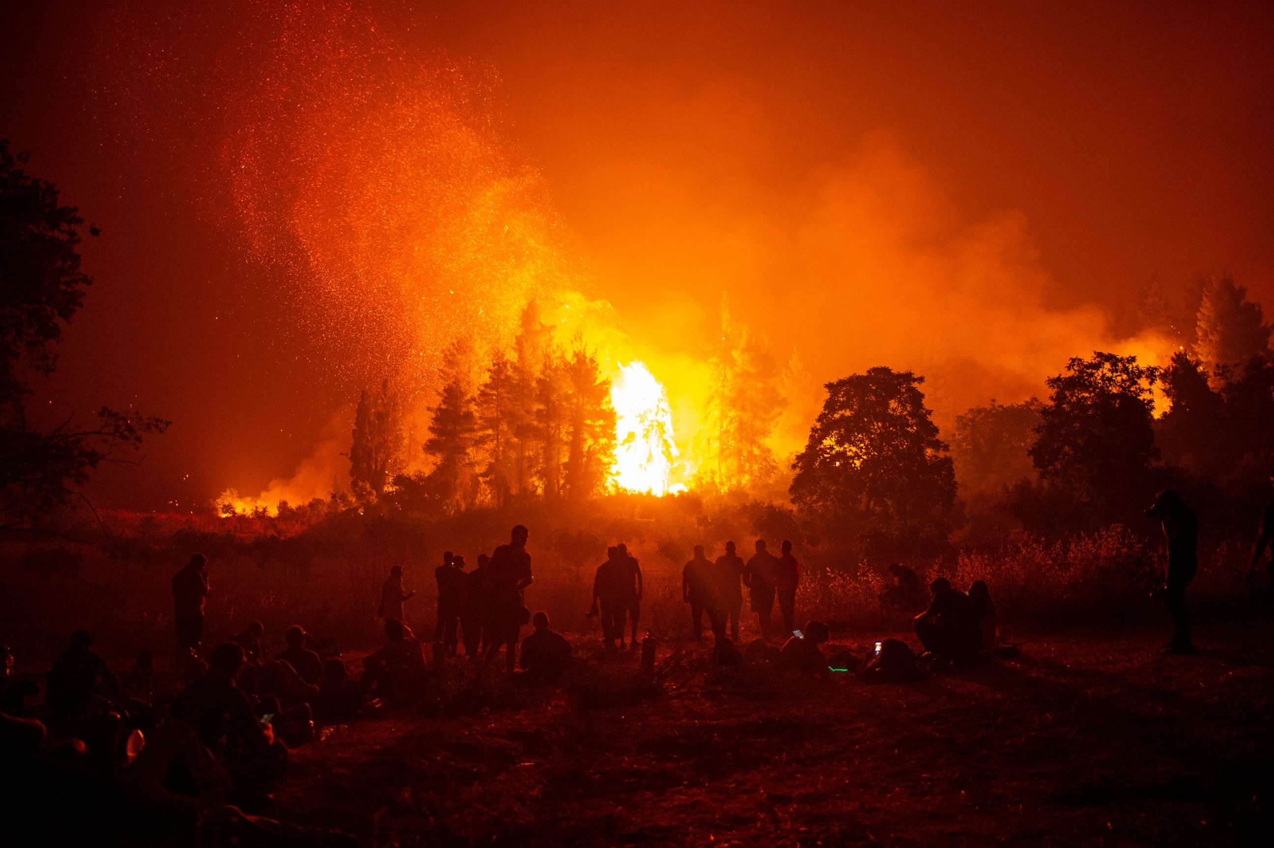PHOTO: Local youths and volunteers gather in an open field and wait to support firefighters during a wildfire next to a village in northern Evia island on Aug. 9, 2021.
