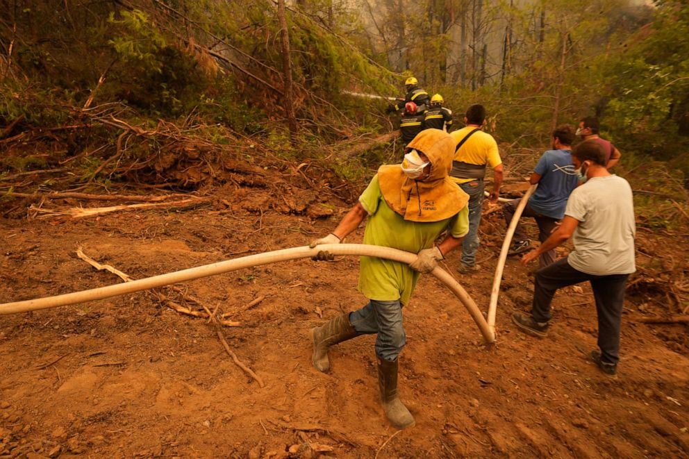 PHOTO: Local residents help firefighters to extinguish a wildfire on Evia island, Greece, Aug. 10, 2021. Firefighters battled for an eighth day as the nation endured what the prime minister described as "a natural disaster of unprecedented proportions."