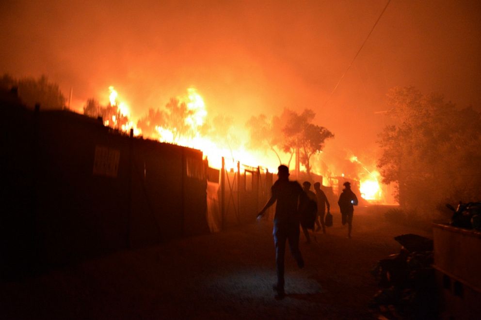 PHOTO: Refugees and migrants flee as a fire burns in the Moria refugee camp on the island of Lesbos, Greece, on Sept. 9, 2020.