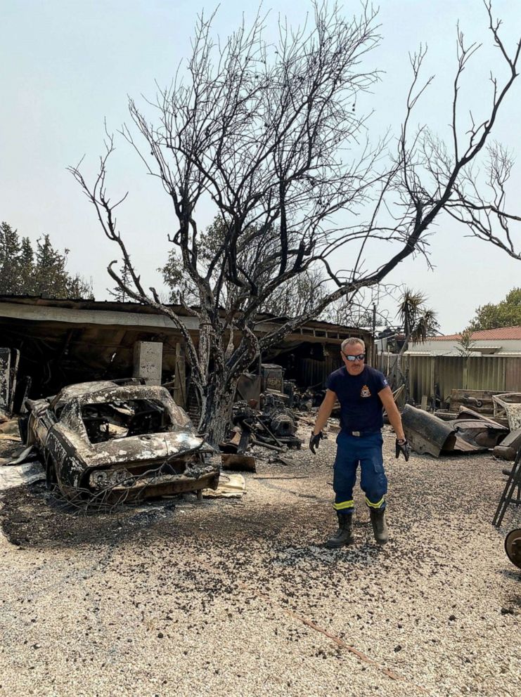 PHOTO: Firefighters cool down hot spots in Varympompi, Greece.