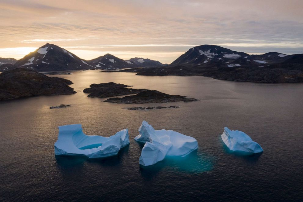 PHOTO: Large icebergs float away as the sun rises near Kulusuk, Greenland, Aug. 16, 2019.