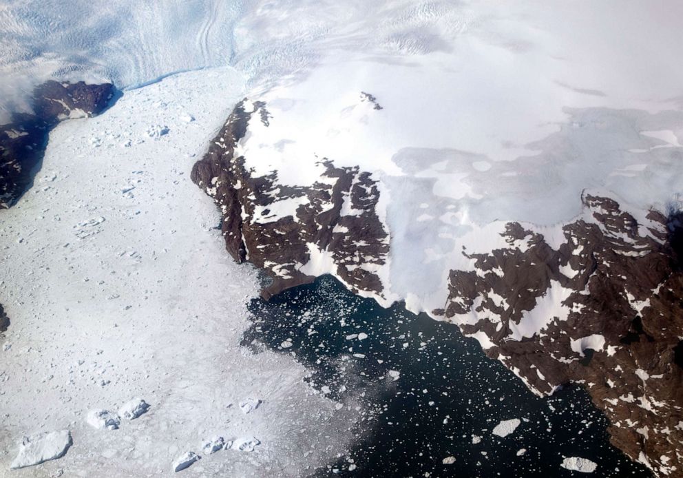 PHOTO: In this file photo dated Thursday, Aug. 3, 2017, a glacier at left calves icebergs into a fjord off the Greenland ice sheet in southeastern Greenland.