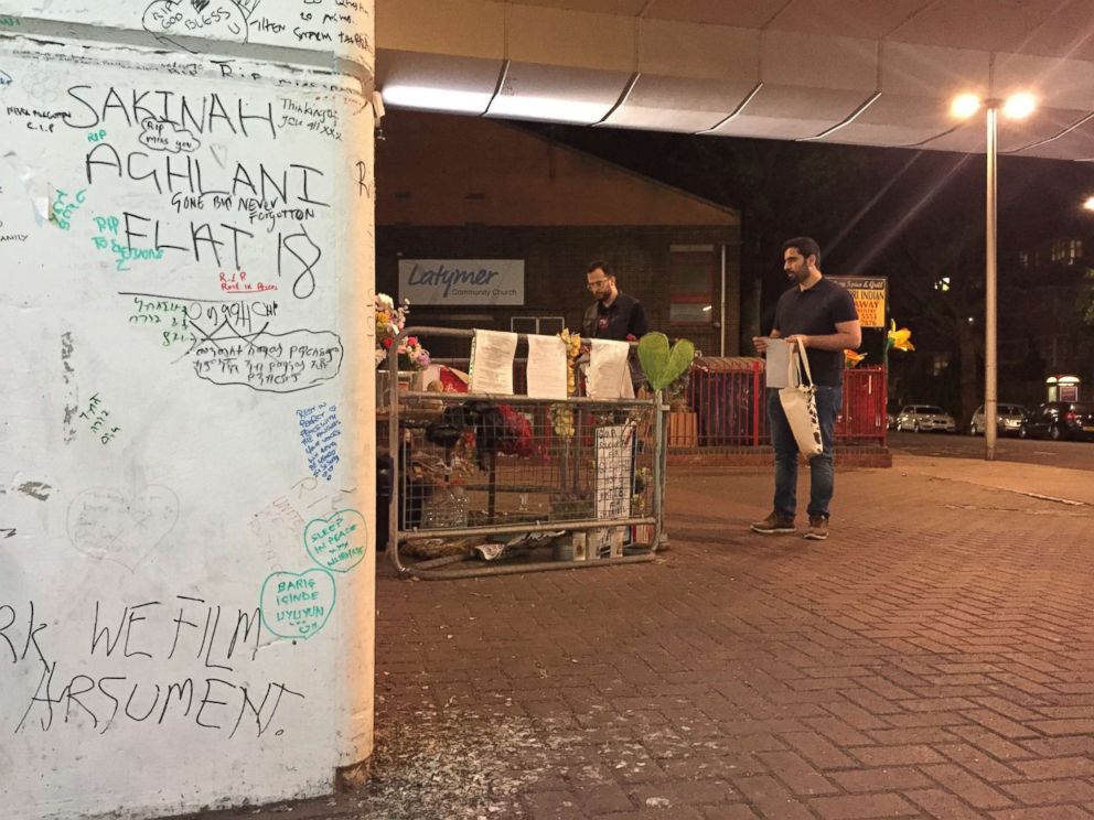 PHOTO: Omar Alhaj Ali and Mahmoud Alkarad walk near a memorial for the victims of the Grenfell Tower fire.