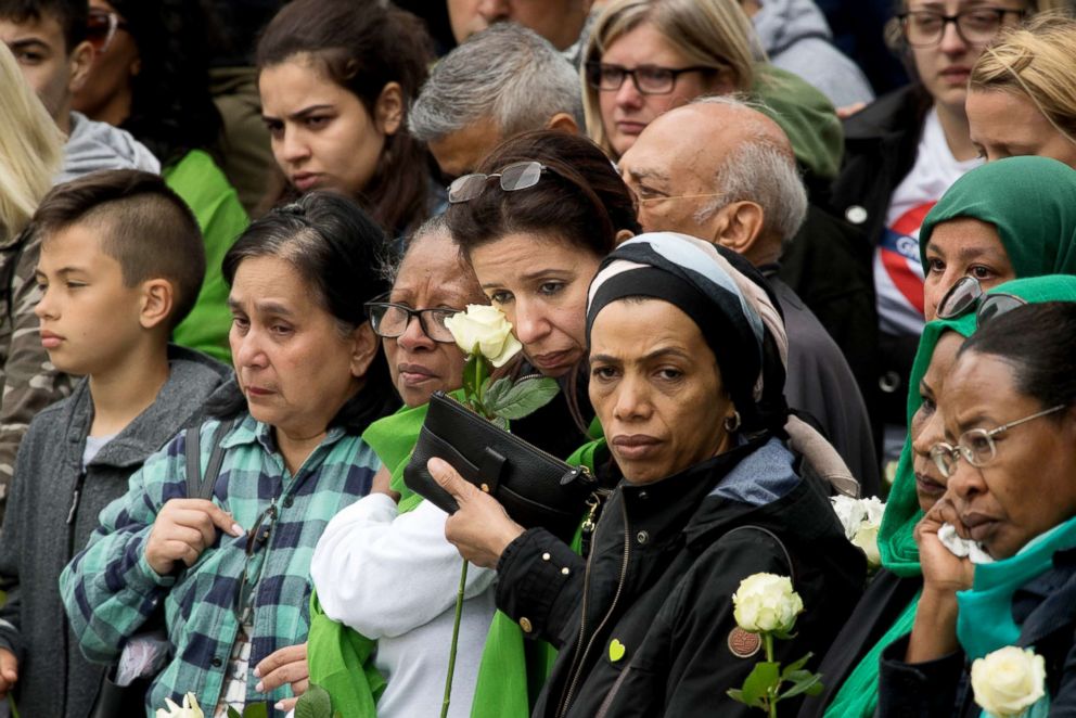 PHOTO: People attend a service at the base of Grenfell Tower on the one year anniversary of the Grenfell Tower fire, June 14, 2018, in London.