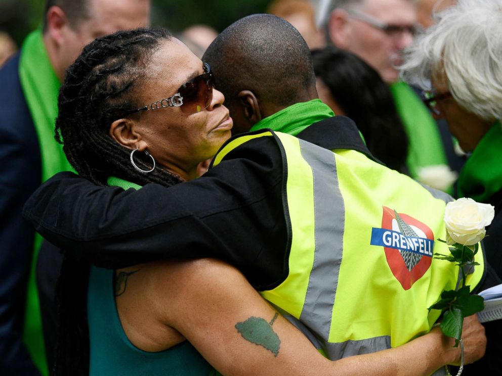 PHOTO: Friends and relatives of victims of the Grenfell fire react before taking part in a silent procession, in tribute to victims as they mark one year anniversary of the fire in London, June 14, 2018.