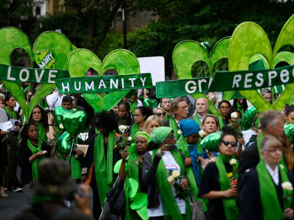 PHOTO: Friends and relatives of victims of the Grenfell fire wear symbolic green, as they take part in a silent procession to mark the one year anniversary of the fire in London, June 14, 2018.