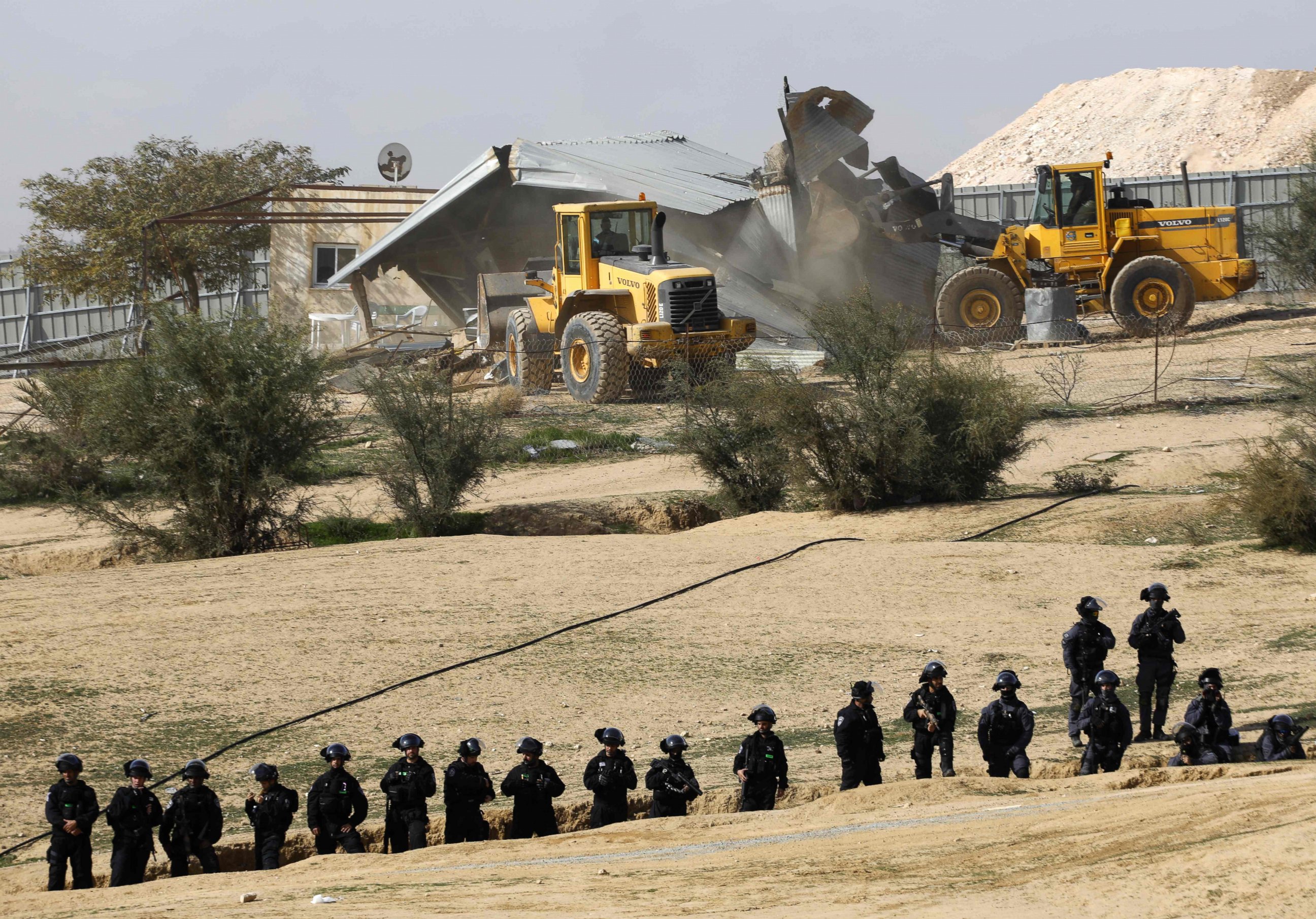 PHOTO: Israeli policemen stand guard as bulldozers demolish homes in the Bedouin village of Umm al-Hiran, which is not recognized by the Israeli government, near the southern city of Beersheba, in the Negev desert, on Jan. 18, 2017.