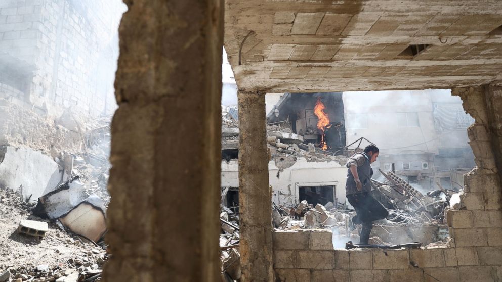 A Syrian man walks amid the rubble of destroyed buildings following reported government airstrike on the rebel-held town of Douma, on the eastern outskirts of the capital Damascus, Feb. 26, 2017.

