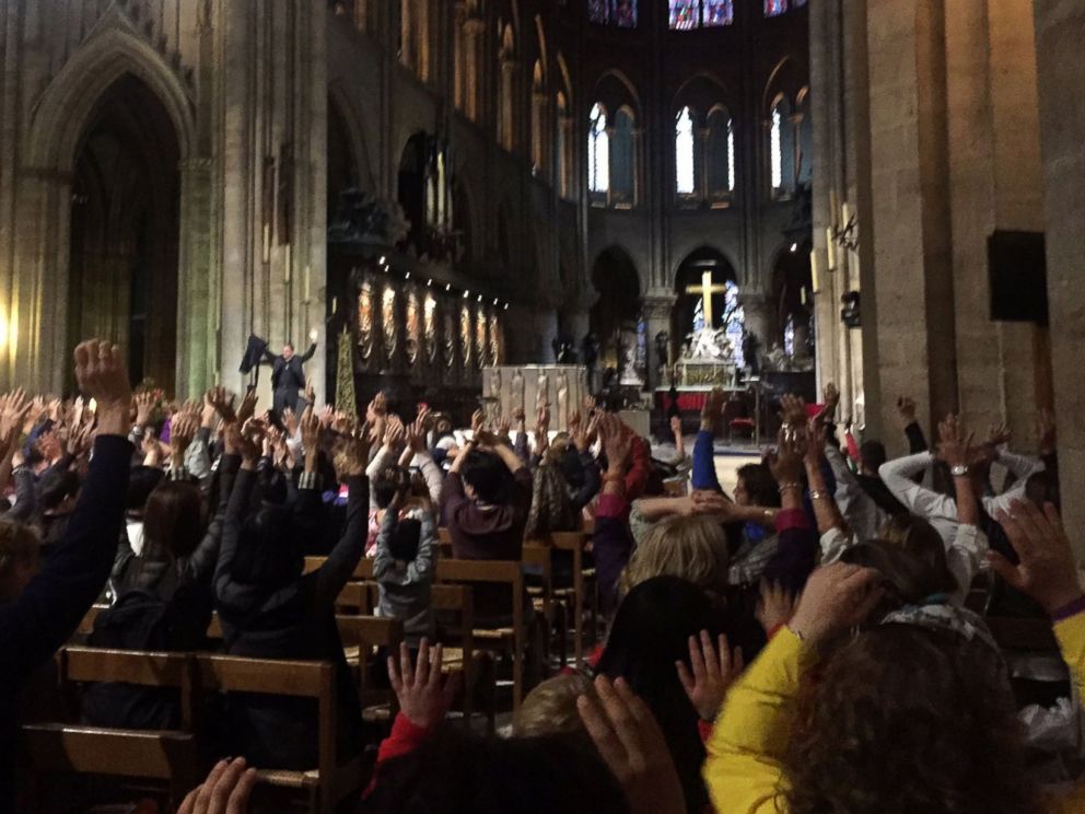 PHOTO: People inside the Notre-Dame Cathedral raise their hands as requested by the police before exiting the church, after a French police shot and injured a man who attacked an officer with a hammer outside the cathedral in Paris, June 6, 2017.