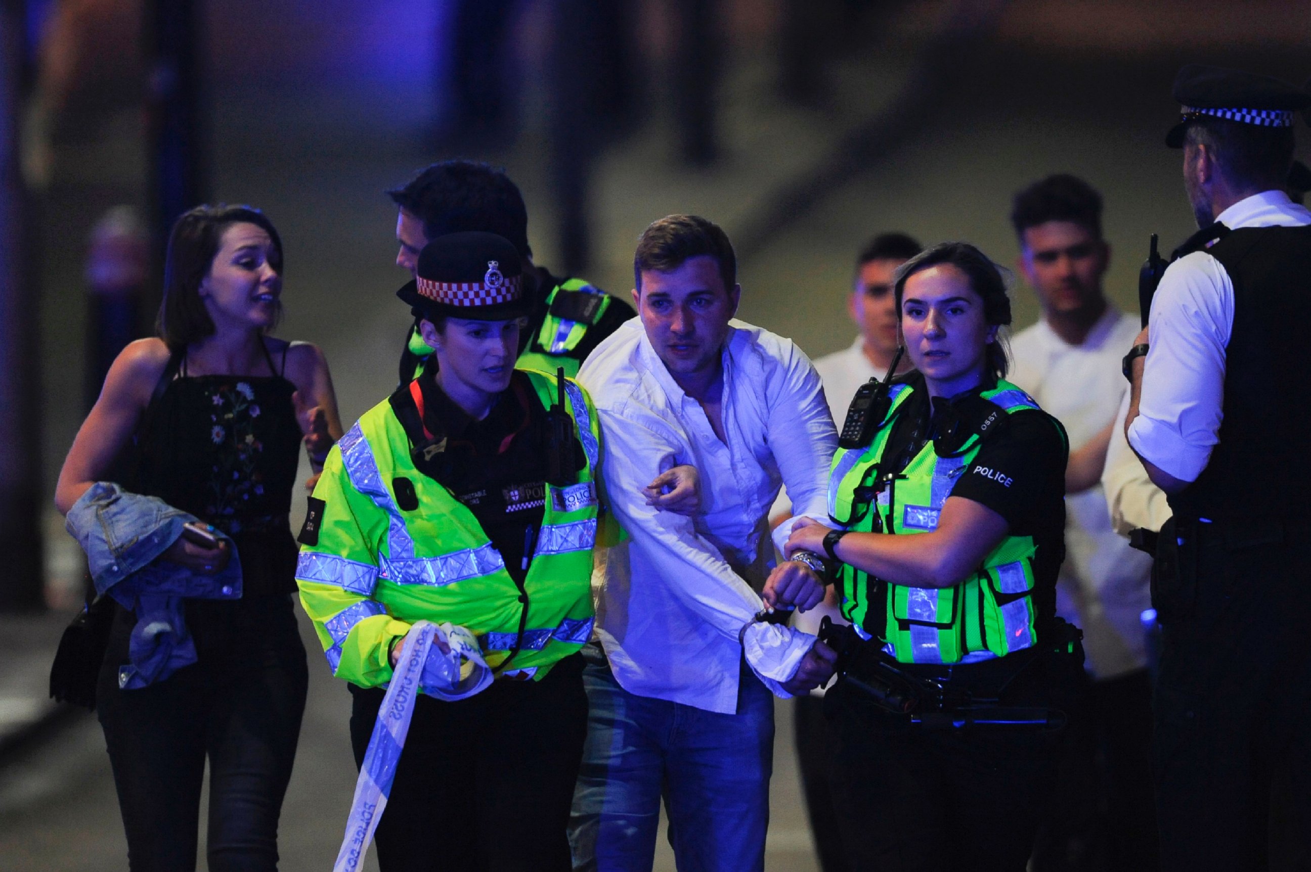 PHOTO: Police escort a member of public as they clear the scene of a terror attack on London Bridge in central London on June 3, 2017.