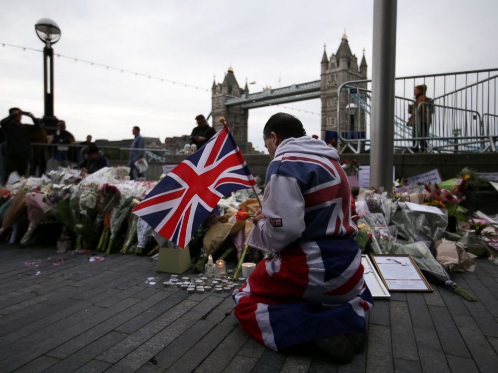 PHOTO: A man holds a Union flag as he kneels near flowers laid at Potters Fields Park in London, June 5, 2017, during a vigil to commemorate the victims of the terror attack on London Bridge.