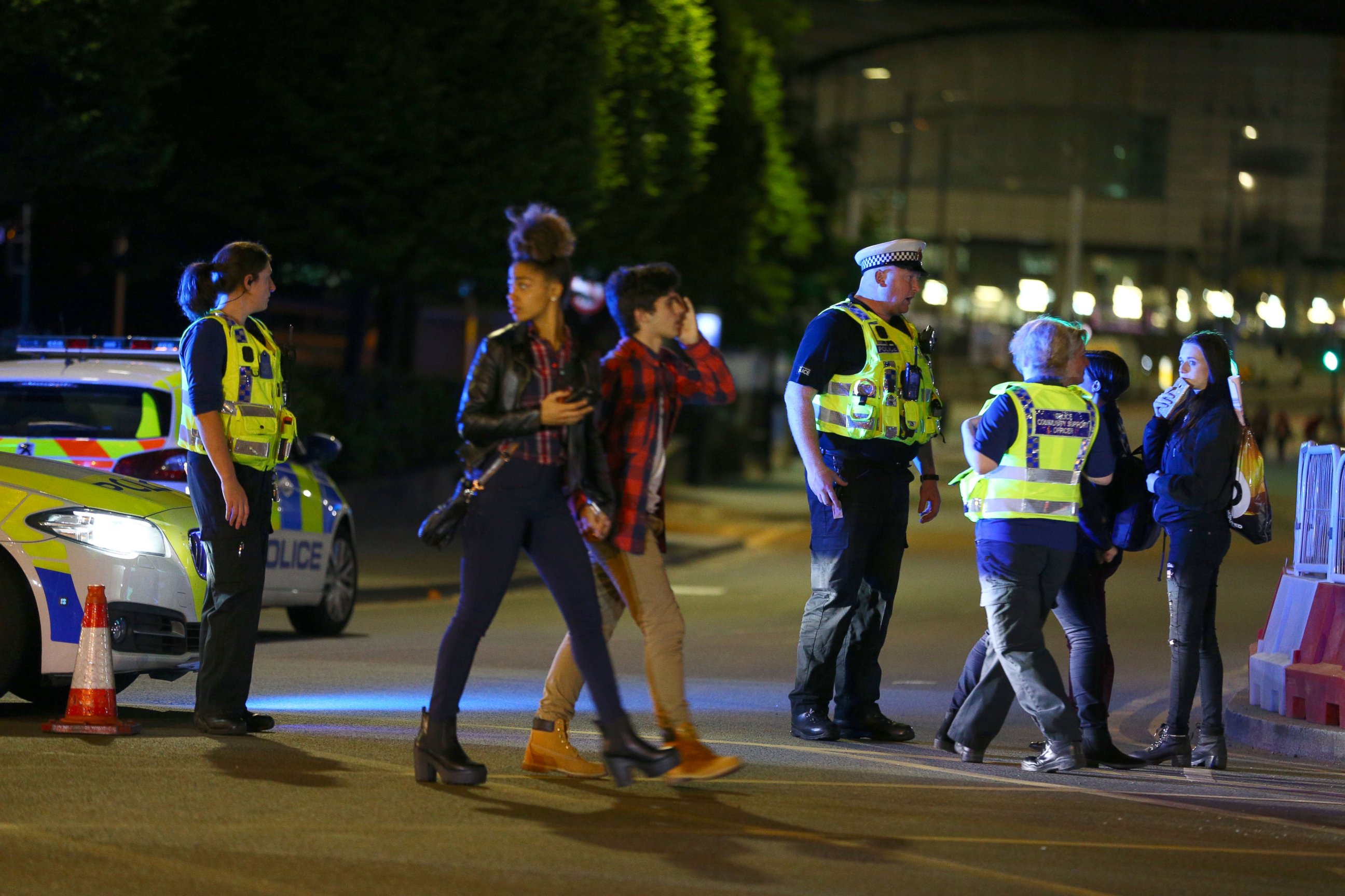 PHOTO: People walk past police near the Manchester Arena on May 23, 2017 in Manchester, England.