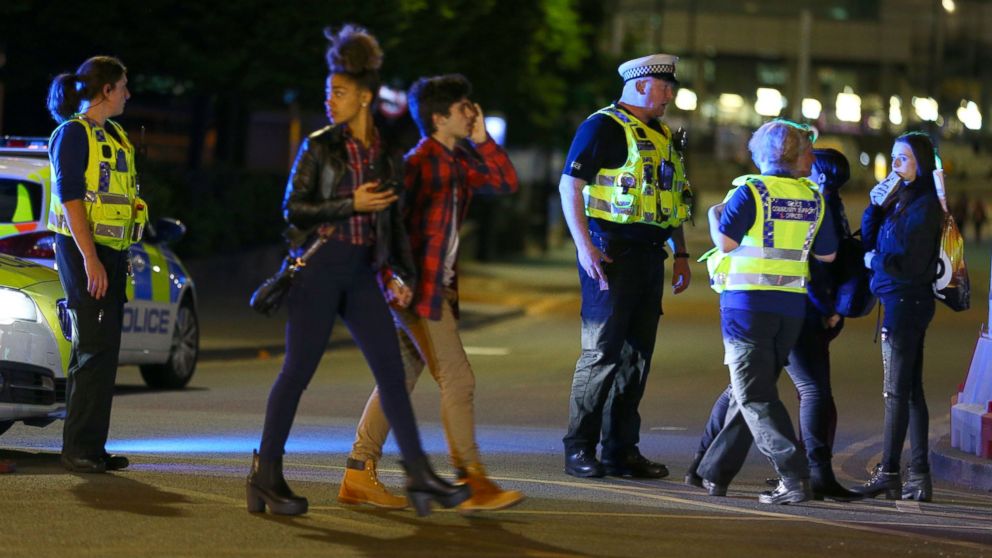 PHOTO: People walk past police near the Manchester Arena on May 23, 2017 in Manchester, England.