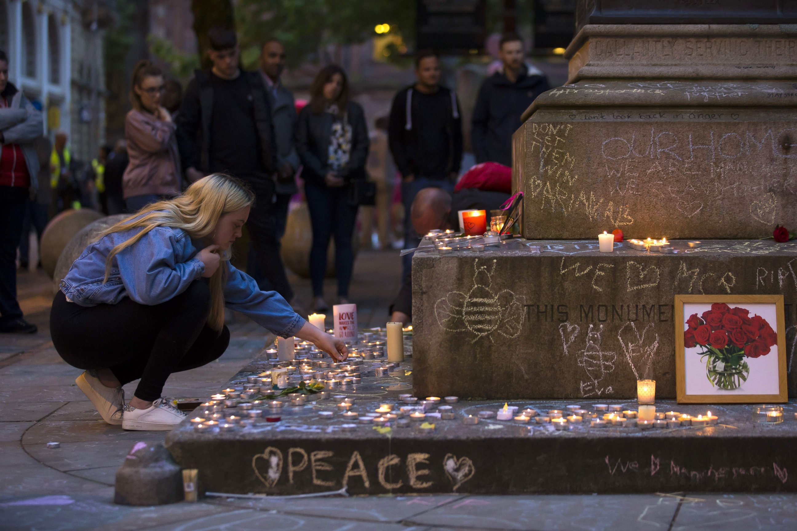 PHOTO: A member of the public lights memorial candles before a vigil in St Ann's Square in Manchester, north west England on May 29, 2017, placed in tribute to the victims of the May 22 terror attack at the Manchester Arena.
