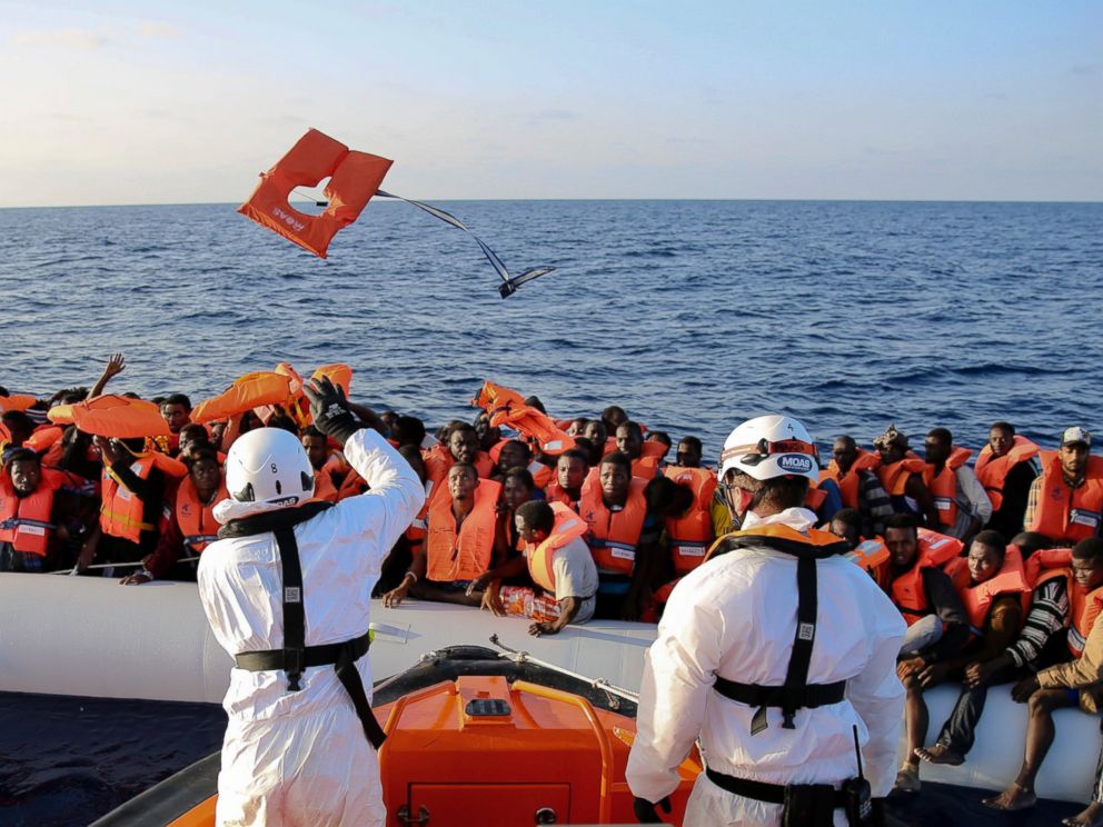 PHOTO: Safety jackets are thrown to migrants on a rubber dinghy from the vessel Responder, run by the Malta-based NGO Migrant Offshore Aid Station (MOAS) and the Italian Red Cross.