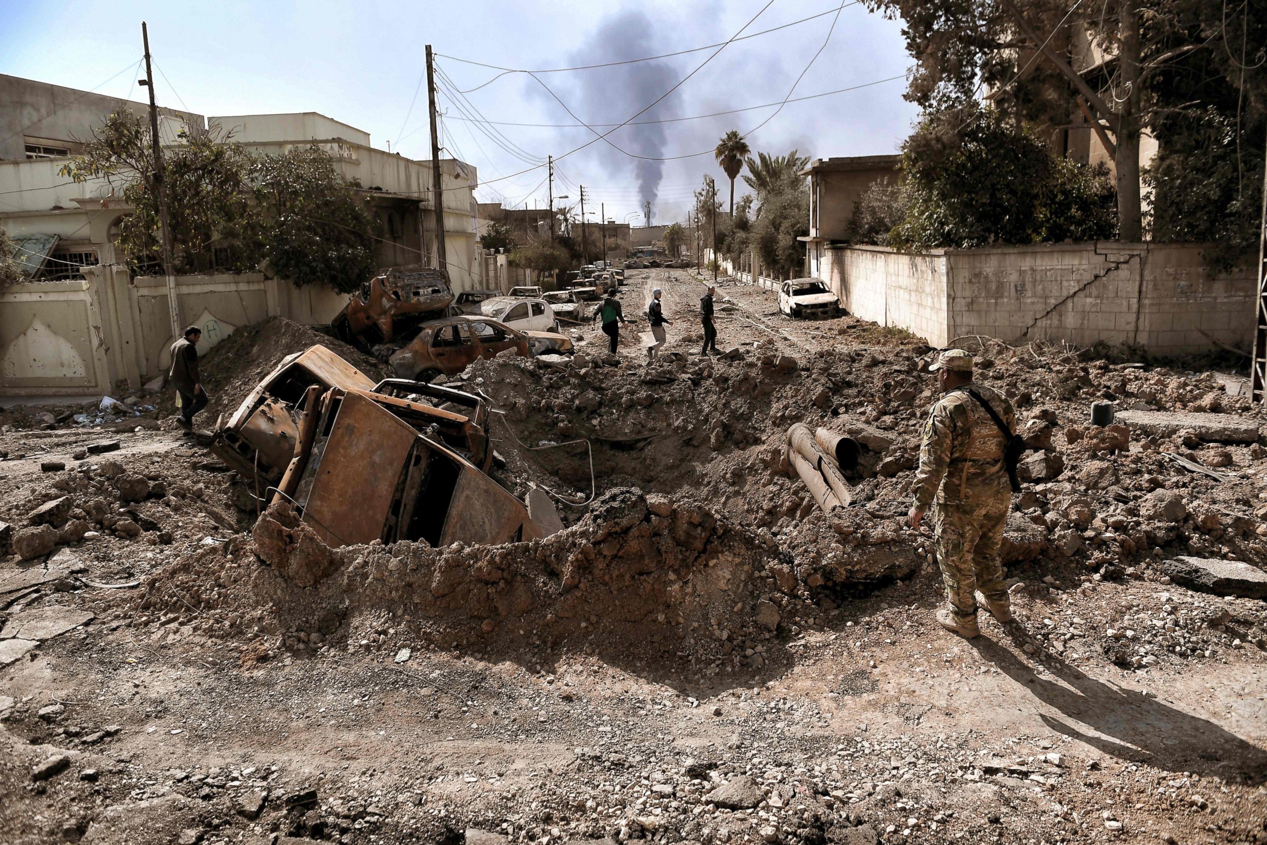 PHOTO: A member of the Iraqi military looks at a crater made by an air strike in west Mosul as Iraqi troops continue battling against Islamic State fighters to further advance inside the city, on March 7, 2017. 