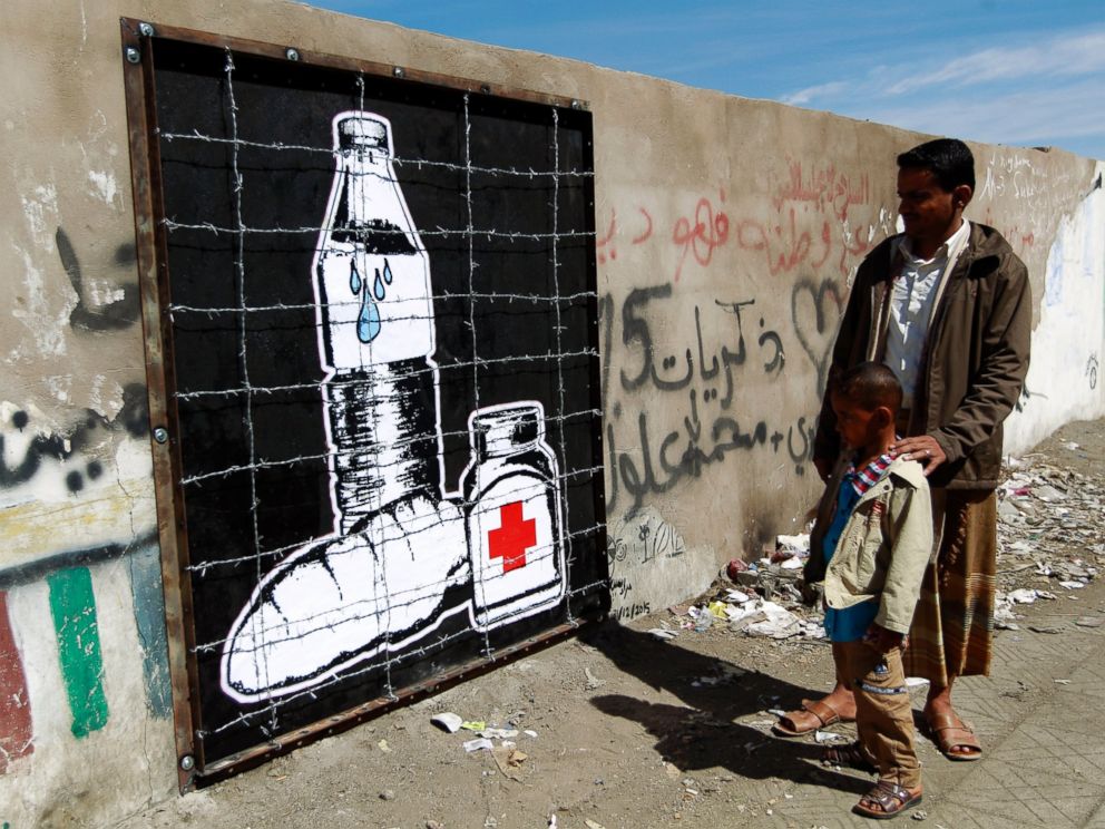 PHOTO: Yemenis look at a piece of art by Murad Subay depicting the blockade in Yemen and the prevention of the entry of food and medicine due to the military campaign against Iran-backed rebels, in Sanaa, Yemen, Dec. 31, 2015.