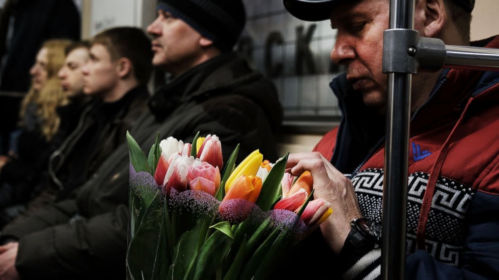 PHOTO: A man holds flowers while riding a Moscow subway on March 6, 2017.