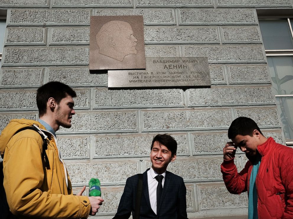PHOTO: Students stand under a picture of Vladimir Lenin in downtown Moscow on March 9, 2017.