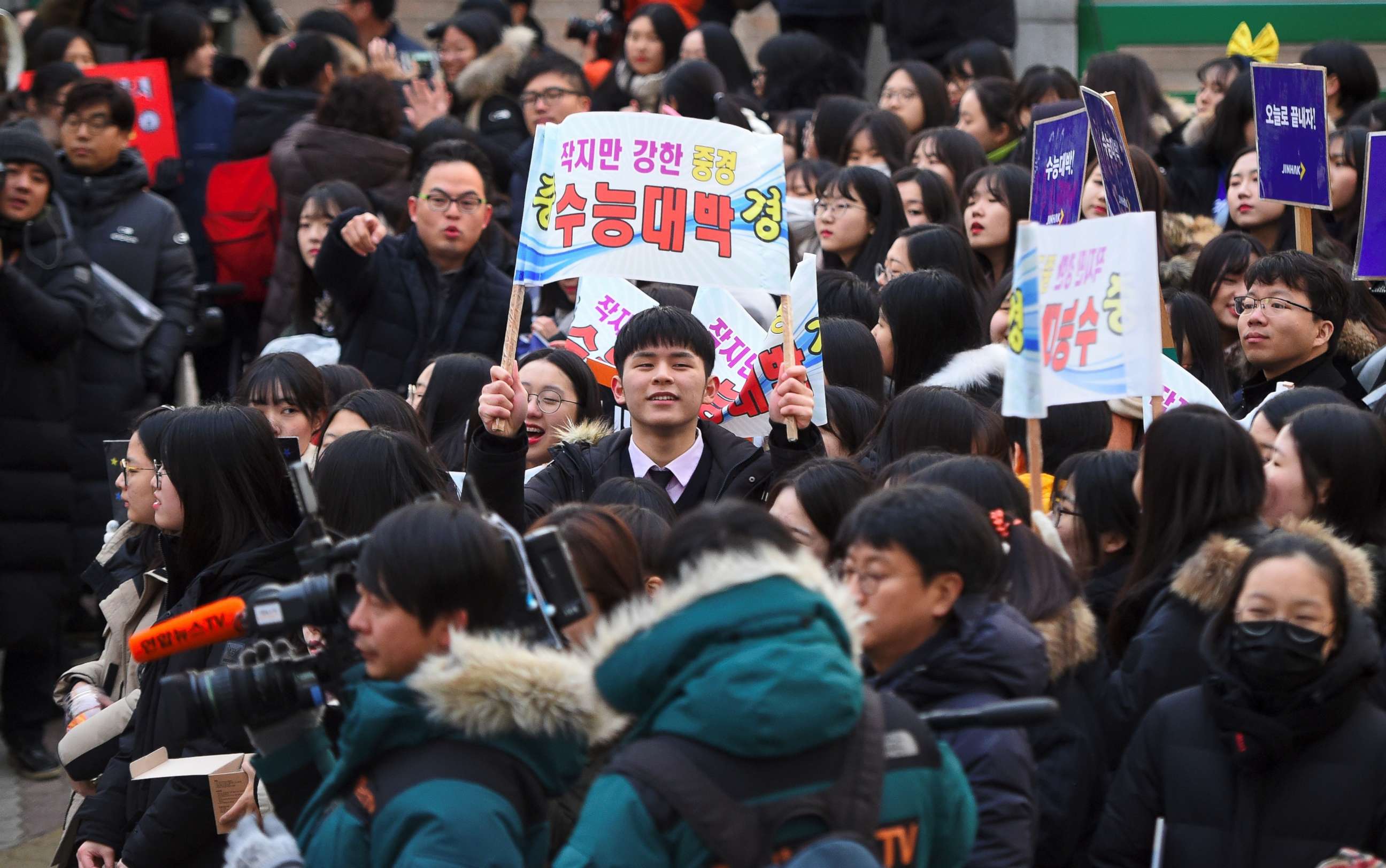 High school students cheer their seniors taking the annual College Scholastic Ability Test, a standardized exam for college entrance, at a high school in Seoul on November 23, 2017.
