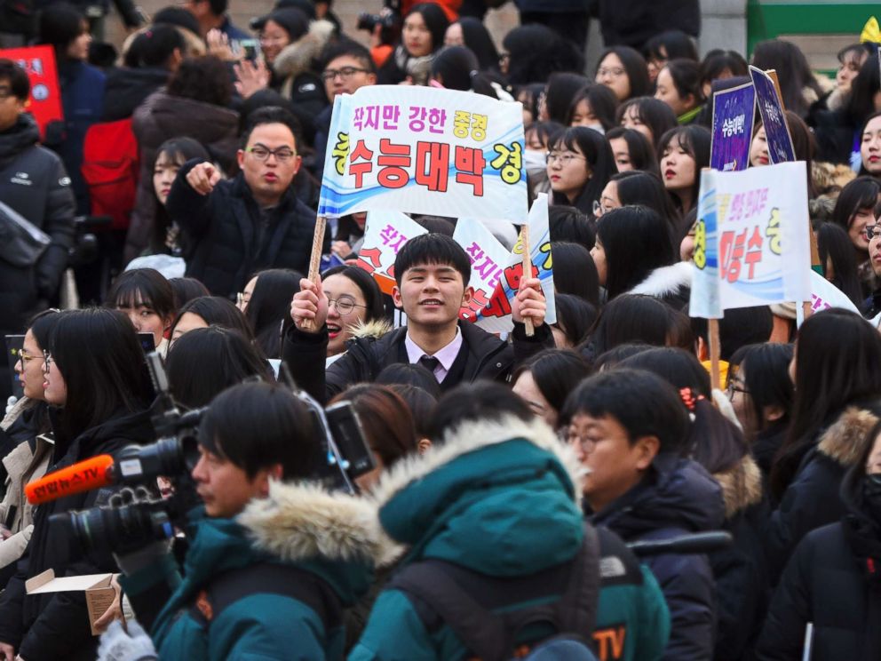 High school students cheer their seniors taking the annual College Scholastic Ability Test, a standardized exam for college entrance, at a high school in Seoul on November 23, 2017.
