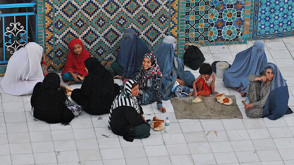 Afghan women wait to break their fast during the holy month of Ramadan at the Hazrat-e Ali shrine in Mazar-i Sharif in northern of Afghanistan on July 17, 2013.