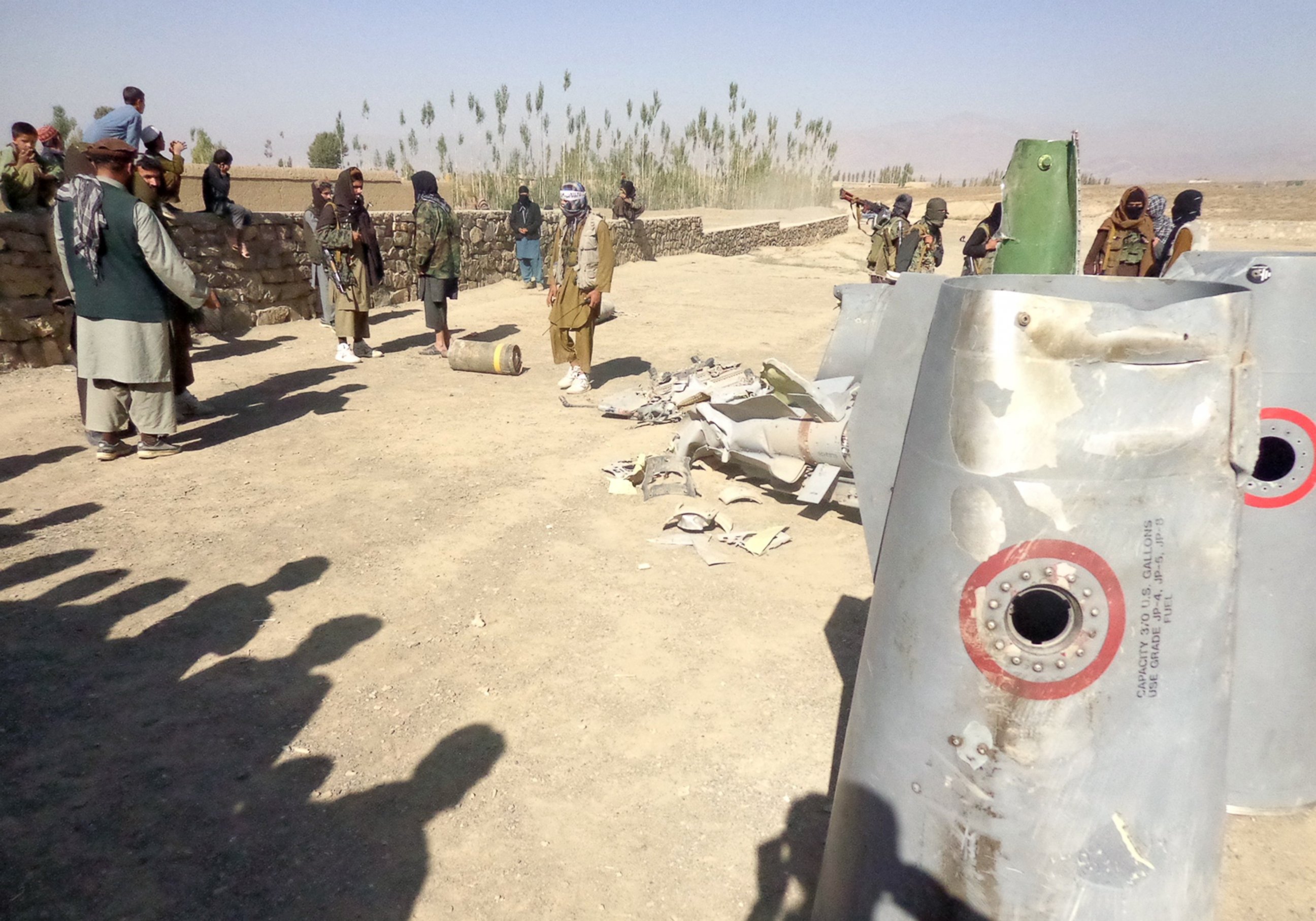 PHOTO: In this photograph taken on Oct.13, 2015, Afghan Taliban militants gather around parts of a US F-16 aircraft that was struck over in Sayid Karam district of eastern Paktia province.