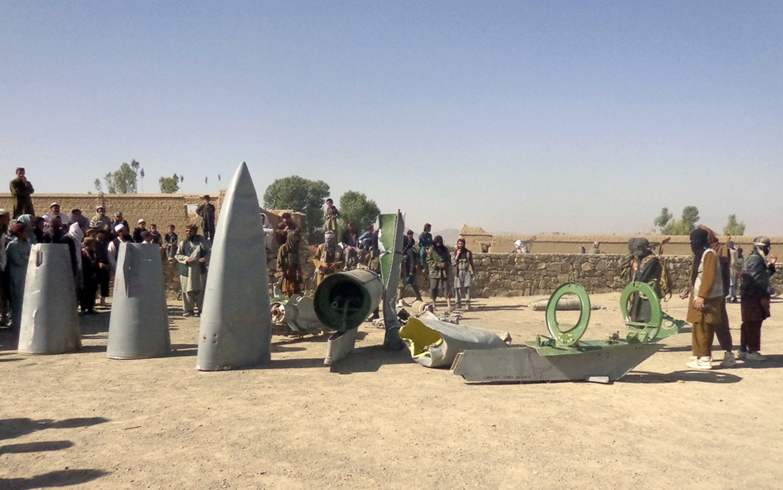 PHOTO: In this photograph taken on Oct.13, 2015, Afghan Taliban militants gather around parts of a US F-16 aircraft that was struck over in Sayid Karam district of eastern Paktia province.