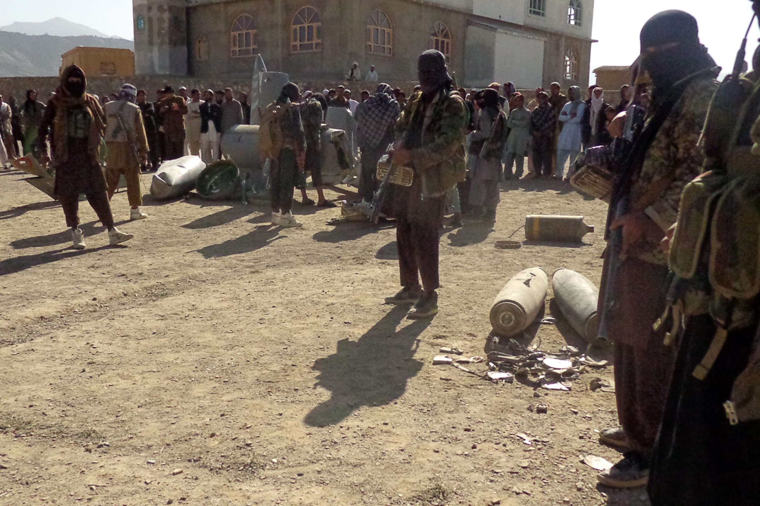 PHOTO: In this photograph taken on Oct.13, 2015, Afghan Taliban militants gather around parts of a US F-16 aircraft that was struck over in Sayid Karam district of eastern Paktia province.