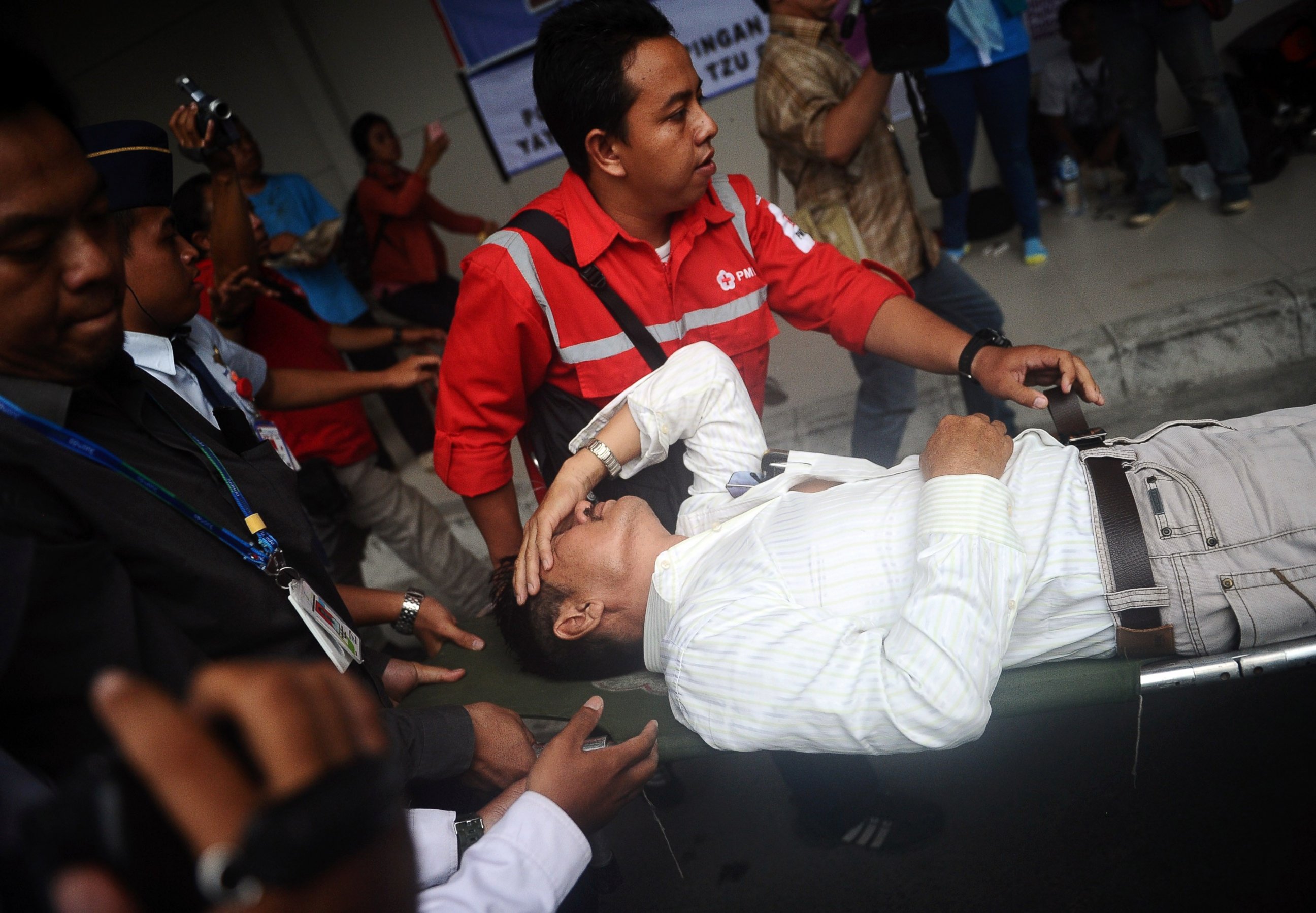 PHOTO: A relative of passengers on AirAsia flight QZ 8501 receives medical attention as he collapses at the breaking news of debris and bodies being found on Dec. 30, 2014 in Surabaya, Indonesia. 