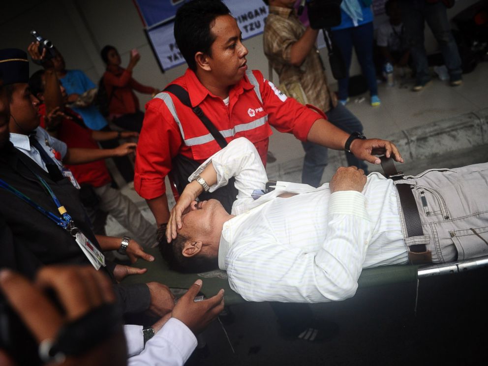 PHOTO: A relative of passengers on AirAsia flight QZ 8501 receives medical attention as he collapses at the breaking news of debris and bodies being found on Dec. 30, 2014 in Surabaya, Indonesia.