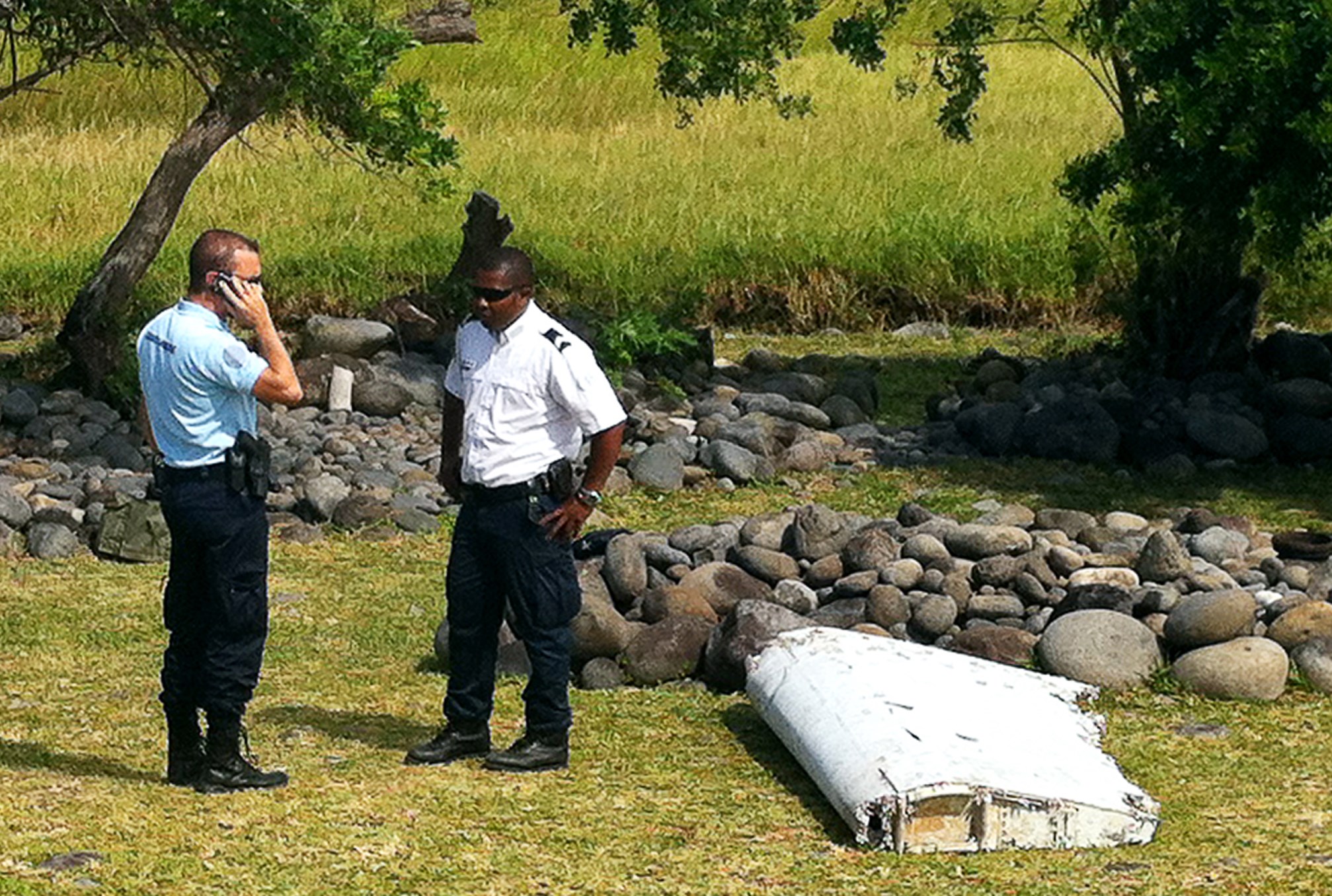 PHOTO: Policemen stand next to a piece of debris from an unidentified aircraft, July 29, 2015, found in the coastal area of Saint-Andre de la Reunion, in the east of the French Indian Ocean island of La Reunion