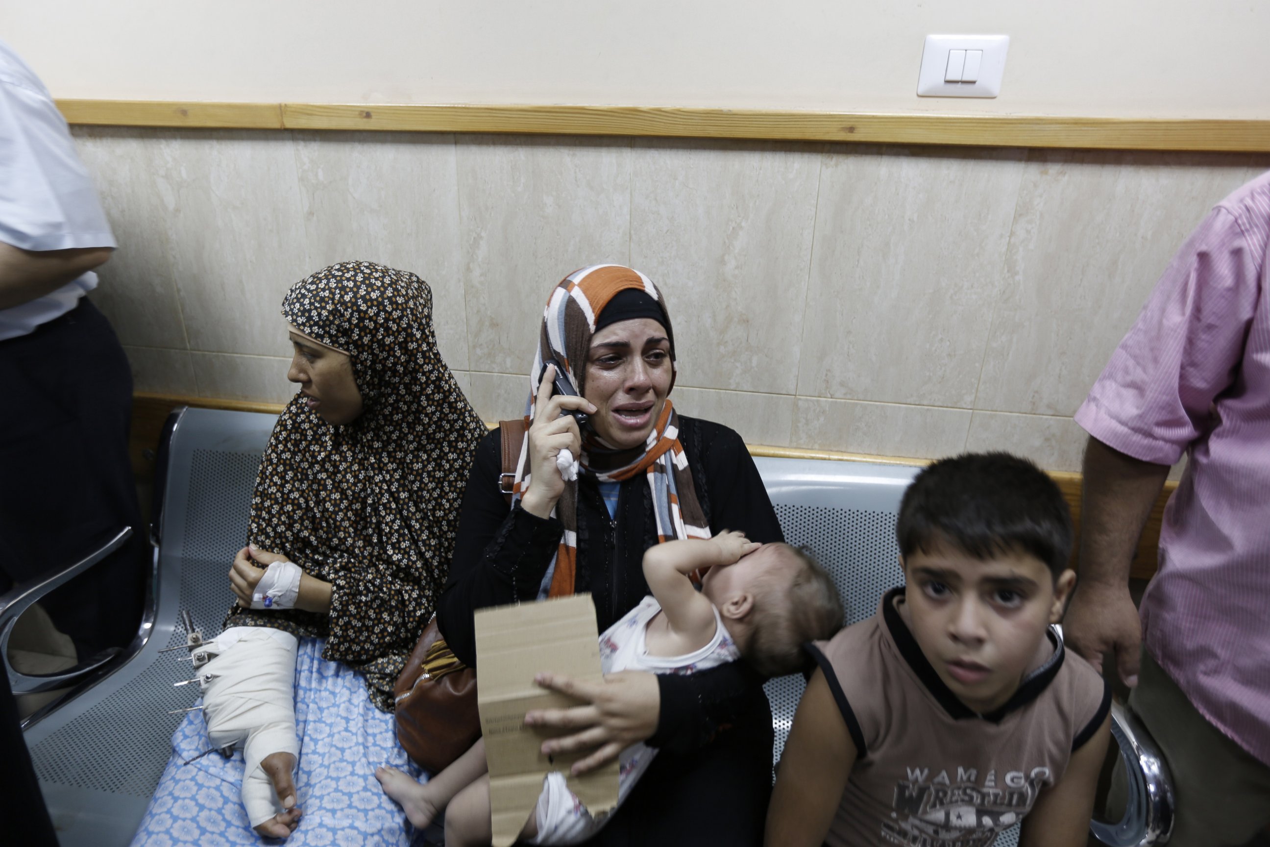 PHOTO: Palestinian patients sit in a hallway of the Al-Aqsa Martyrs hospital in Deir al-Balah in the Gaza Strip after the building was hit by an Israeli army shelling on July 21, 2014.