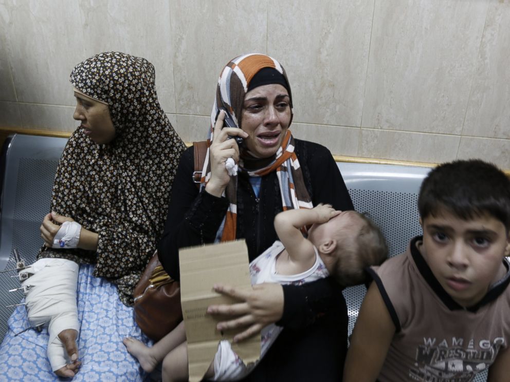 PHOTO: Palestinian patients sit in a hallway of the Al-Aqsa Martyrs hospital in Deir al-Balah in the Gaza Strip after the building was hit by an Israeli army shelling on July 21, 2014.