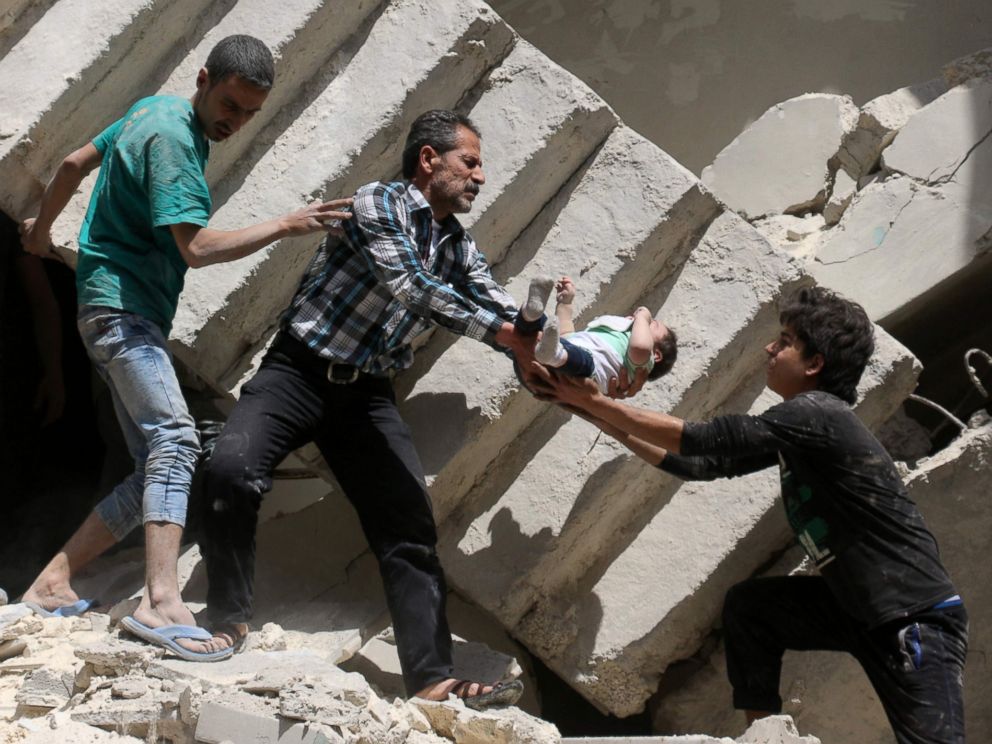 PHOTO: Syrian civil defense volunteers and rescuers remove a baby from under the rubble of a destroyed building following an air strike on the rebel-held neighborhood of al-Kalasa in the northern Syrian city of Aleppo, on April 28, 2016.