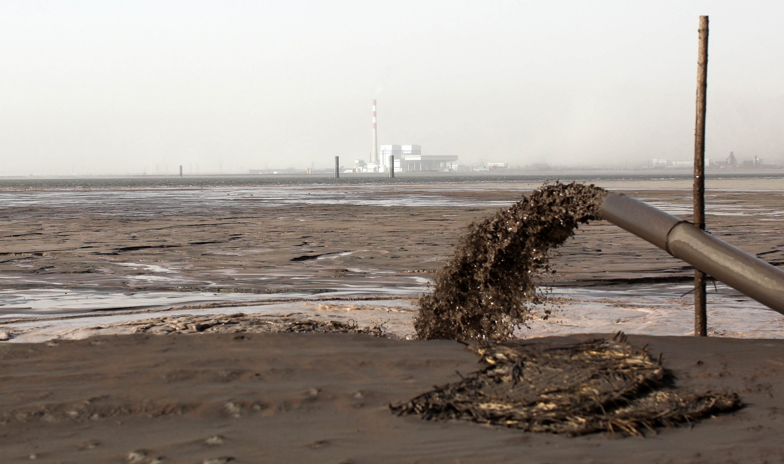 PHOTO: Rare earth discharge liquid outflows from a pipeline into a "rare earth lake" near Xinguang village on Nov. 26, 2010 in Baotou, Inner Mongolia of China.