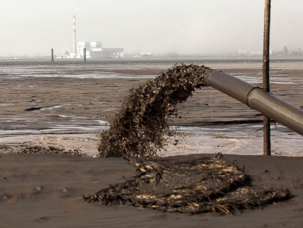 PHOTO: Rare earth discharge liquid outflows from a pipeline into a rare earth lake near Xinguang village on Nov. 26, 2010 in Baotou, Inner Mongolia of China.