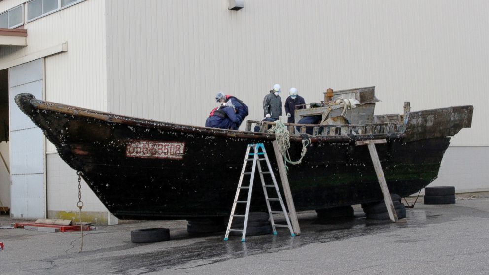 This picture taken on Nov. 24, 2015 shows coast guard officials investigating a wooden boat at the Fukui port in Sakai city in Fukui, Japan.