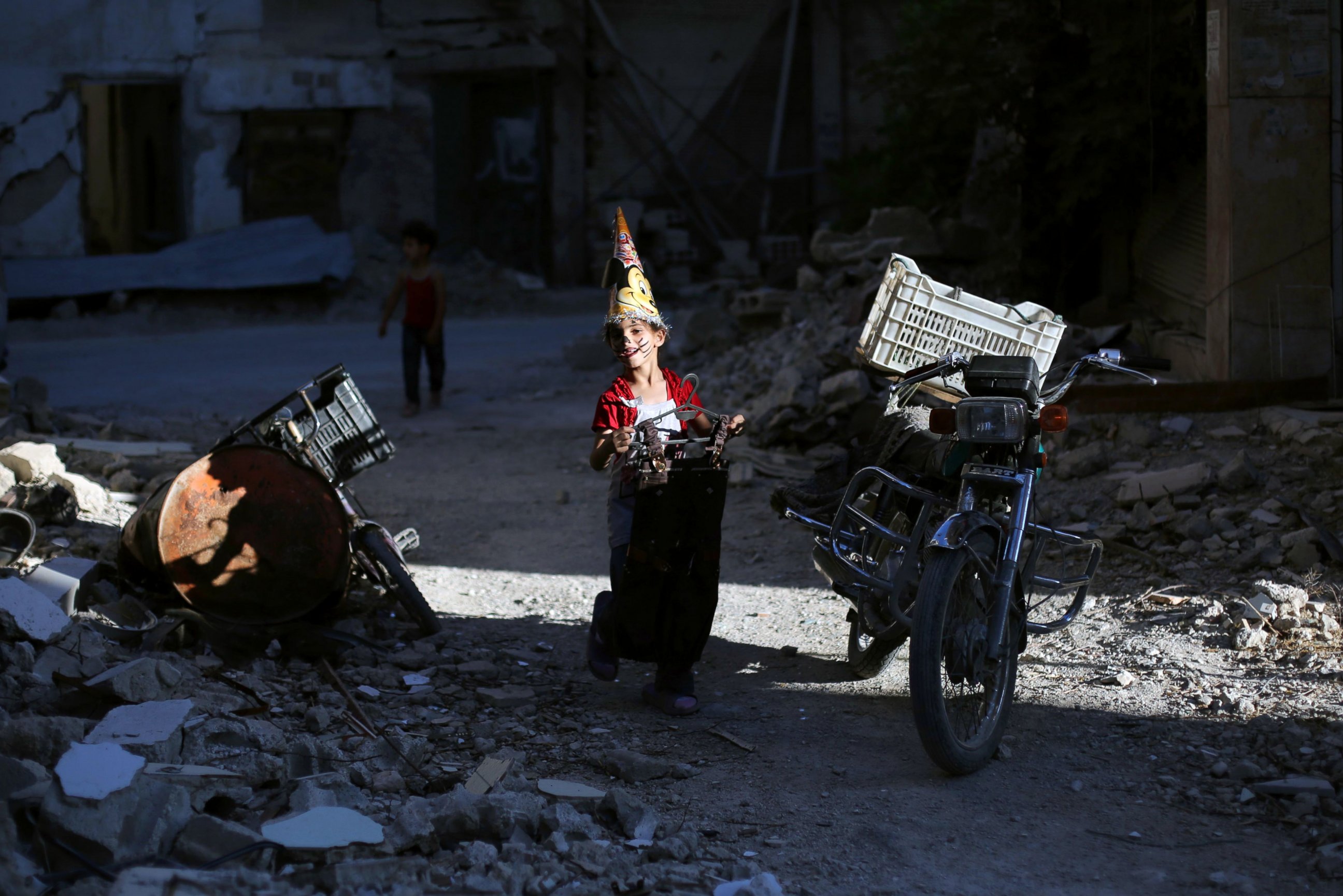 PHOTO: A Syrian girl walks amidst destruction during an activity organized by a charity group in Jobar, ahead of Eid al-Fitr holyday in the war-torn country on July 5, 2016. 